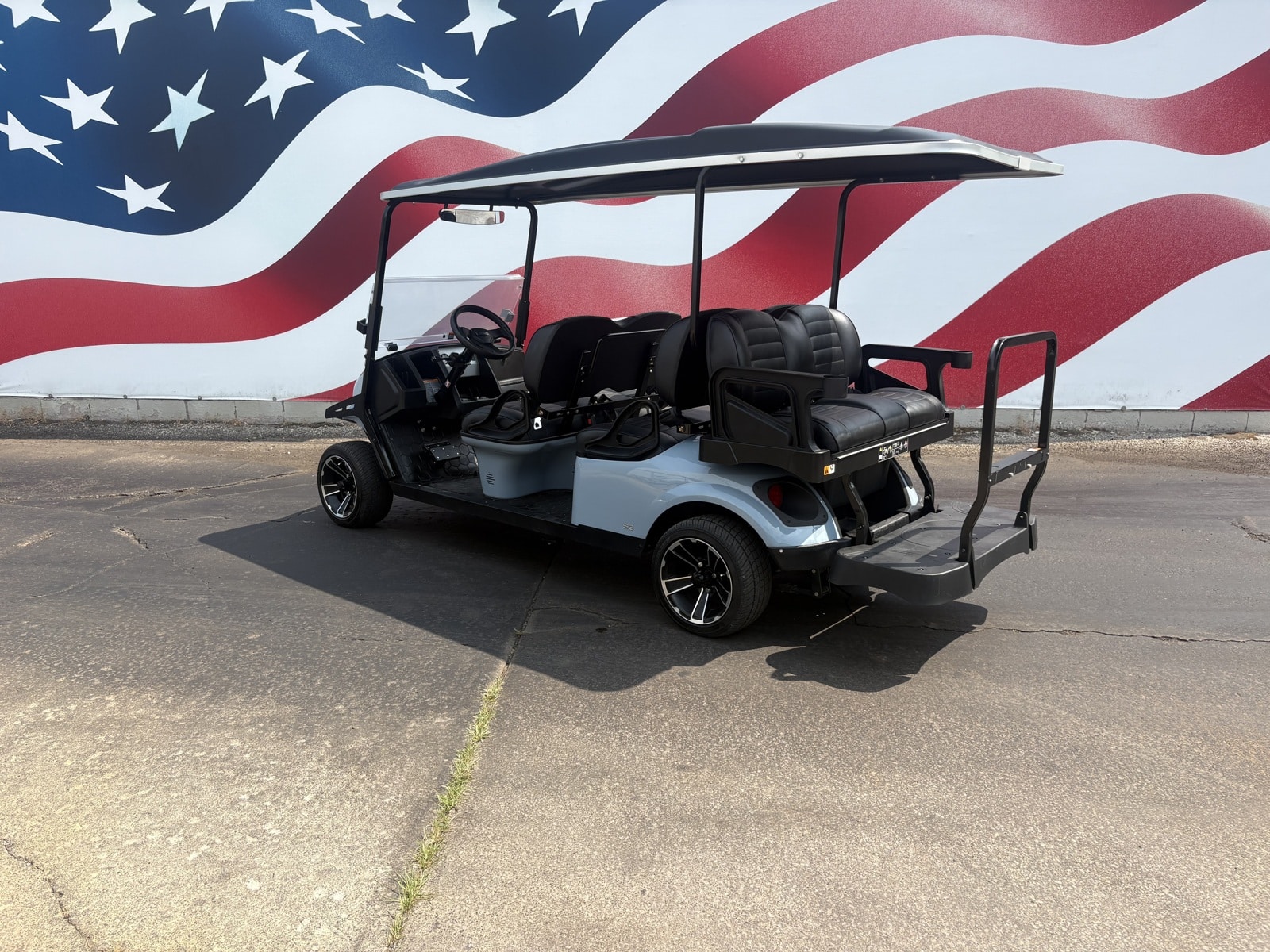 Golf cart with all-terrain tires on a gravel campground road